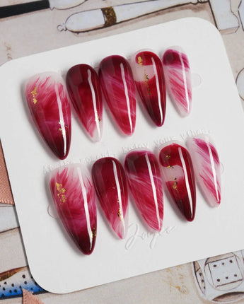 Gone with the Wind medium stiletto press-on nails with marbled burgundy and gold foil accents