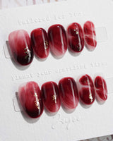Gone with the Wind short oval press-on nails with marbled burgundy gel and gold foil