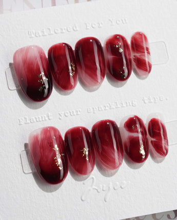 Gone with the Wind short oval press-on nails with marbled burgundy gel and gold foil