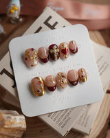 Gothic Red extra short oval press-on nails with ornate metallic crosses and burgundy red