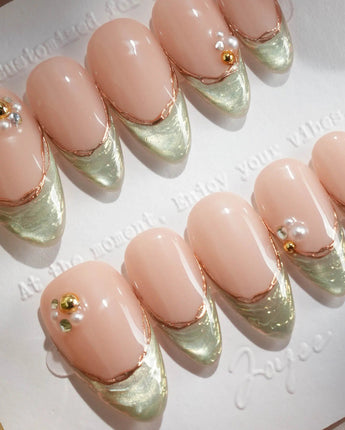 Silk Green - New handmade press-on nails featuring nude pink base sage green french gold outline pearl studs cat eye effect
