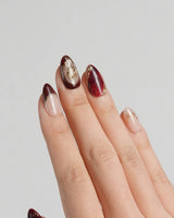 Gilded Merlot press-on nails with deep red cat-eye gel, nude French base and glossy gold details