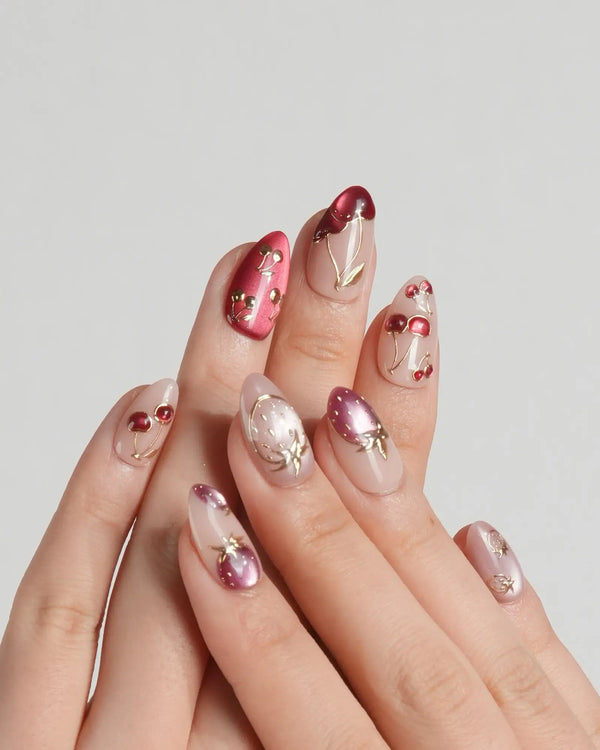 Handmade red cat-eye nails with gold fruit detailing