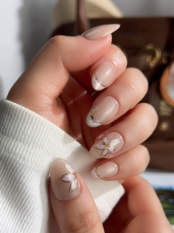 Beige nude press-on nails with gold outlined floral designs