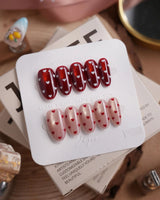 Heart Collector press-on nails in medium oval shape — Vintage Red Pear, Contrasting Red & White Hearts, Cat-eye Shimmer