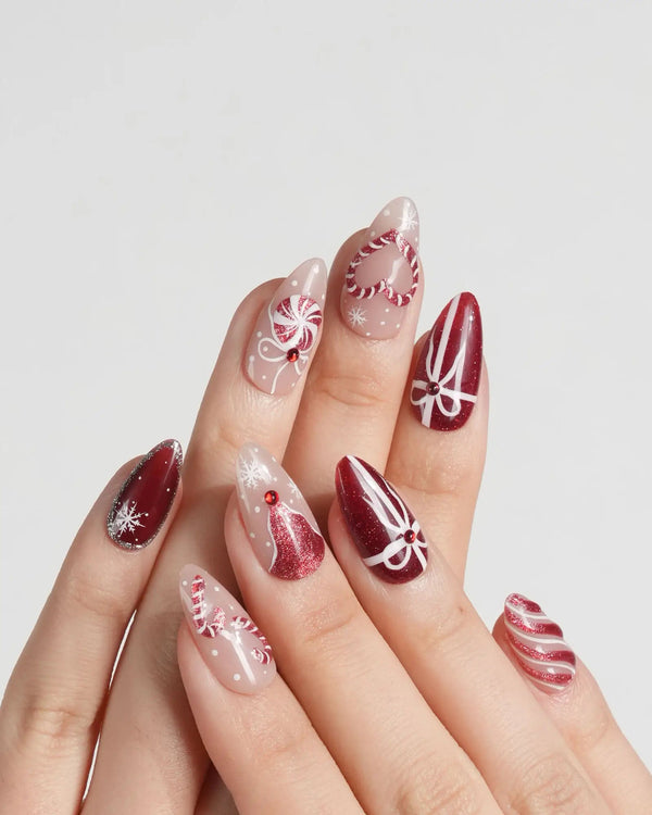 Holiday press-on nails with hand-painted bows and candy stripes