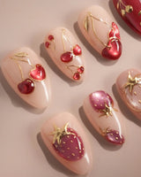 Crystal Berry press-on nails with glossy red cat-eye cherry details and nude accent nails