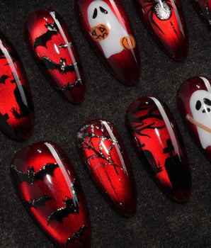 Blood Moon press on nails with black bats, bare trees, a ghost holding a pumpkin and a silver glitter spider on deep red cat eye - image 1