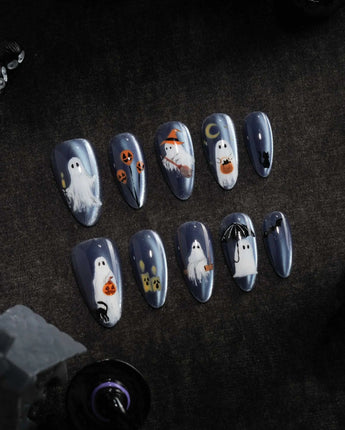 Ghost Errands press on nails with little white ghosts holding a pumpkin, a broom and an umbrella on slate blue cat eye - image 3