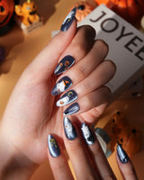 Ghost Errands press on nails with little white ghosts holding a pumpkin, a broom and an umbrella on slate blue cat eye - image 4