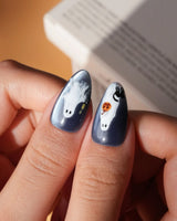 Ghost Errands press on nails with little white ghosts holding a pumpkin, a broom and an umbrella on slate blue cat eye - image 5