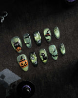 Witch's Cat press on nails with a black cat on a jack-o-lantern, witch hat, skulls, bats and a spider web on green shimmer cat eye - image 1