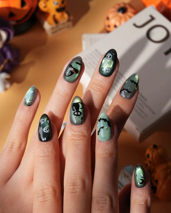 Witch's Cat press on nails with a black cat on a jack-o-lantern, witch hat, skulls, bats and a spider web on green shimmer cat eye - image 2