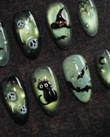 Witch's Cat press on nails with a black cat on a jack-o-lantern, witch hat, skulls, bats and a spider web on green shimmer cat eye - image 3