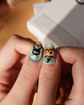Witch's Cat press on nails with a black cat on a jack-o-lantern, witch hat, skulls, bats and a spider web on green shimmer cat eye - image 4