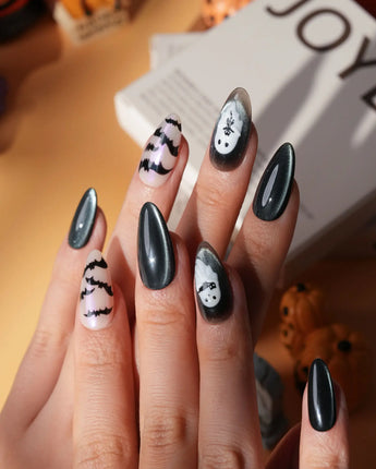 Cat Sitter press on nails with a long-tailed black cat, a row of bats and a white ghost holding a kitten on black and nude with pink shimmer - image 1