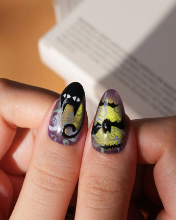 Fright Night press on nails with a fanged black cat, bats, white skulls and spider webs on purple gold and green cat eye - image 6