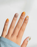 Iced Punch close-up of amber-to-orange jelly nails with miniature cocktail glass charm
