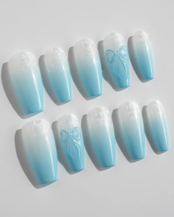 Close up of baby blue nails showing ombre and 3D bow