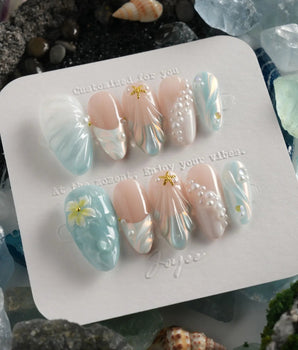 Yasawa Blue island nails with translucent blue swirls, pearl strings, and shell-like texture
