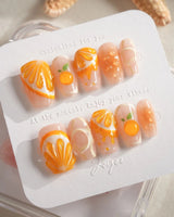 Juicy Juicy glossy citrus press-on nail set in orange and white tones