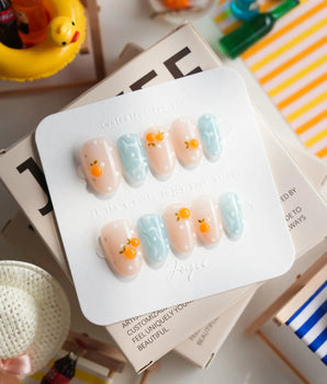 Juicy Summer citrus press-on nails with orange fruit charms and fizzy polka dots