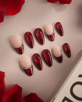Close-up of Brocade press-on nails with deep red rose prints and silver bead chain accents