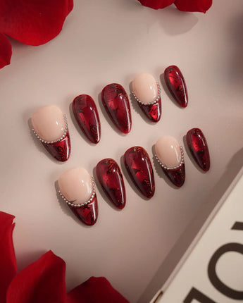 Close-up of Brocade press-on nails with deep red rose prints and silver bead chain accents