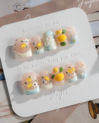 Lemon Shore vacation press-on nails with bright lemons and ocean-blue accents