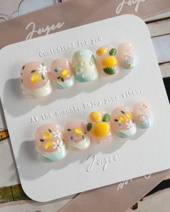 Lemon Shore hand-painted lemon nail art with white blossoms and glossy finish