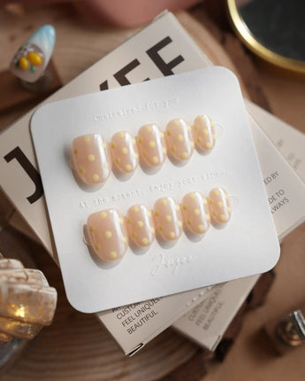 Lemon soda extra short oval press-on nails with pearly nude shimmer and retro polka dots