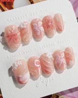 Lily-Nocturne press-on nails in short oval shape — Soft Peach Pink, 3D Lilies & Shell Textures.