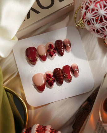 Lily Rouge press-on nails with glossy red cat-eye shimmer and 3D flower accents