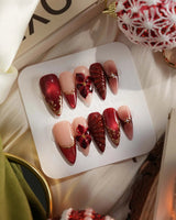 Lily Rouge press-on nails with nude base, red cat-eye French tips and 3D flower accents