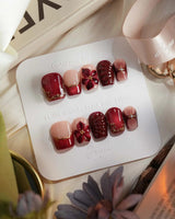 Lily Rouge press-on nails with red cat-eye French design, gold outline and flower accents