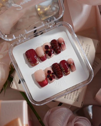Lily Rouge short coffin press-on nails with red cat-eye French tips and 3D flowers
