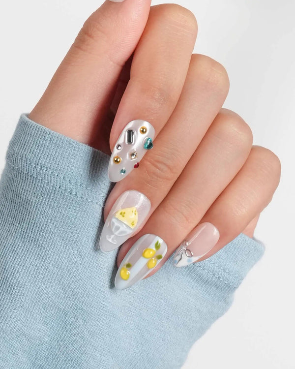 Limoncello short almond nails with 3D lemons, icy blue, nude, and gemstone accents