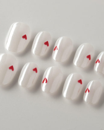 Little Luck press-on nails in extra short oval shape — milky white red heart nails