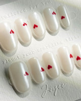 Little Luck press-on nails in short oval shape — milky white red heart nails