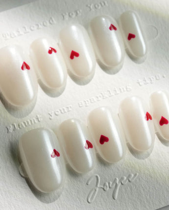 Little Luck press-on nails in short oval shape — milky white red heart nails