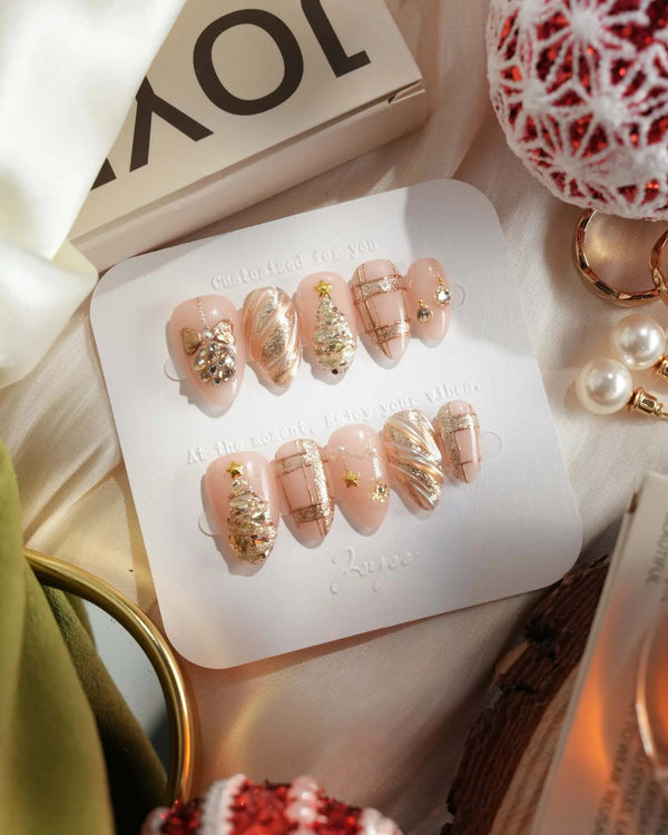 Luxury nude-gold holiday nails with glitter finish