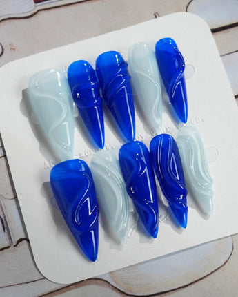 Majorelle Blue long stiletto nails with high-gloss blue swirls and silver-white details