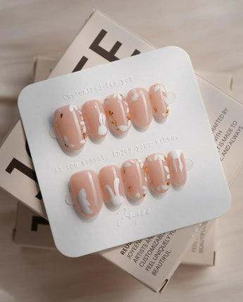 Meadow Bunny nail art close-up showing nude,Hand-painted White Bunnies & Gold Foil Floral Accents details