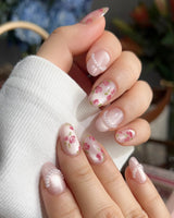 Meadow Glow summer bloom nails with tiny red flowers, light pink gel, and pearls