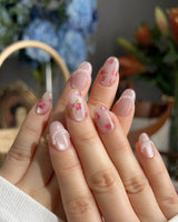 Meadow Glow close-up of vintage pink floral nails with delicate pearl accents