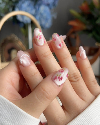 Meadow Glow garden picnic nails with bright floral print, pearls, and glossy pink finish