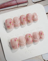 Meadow Glow extra short coffin nails with pink garden florals and glossy pearl detail