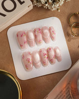 Meadow Glow medium coffin nails with pastel pink base, red blooms, and pearl accents