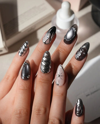 Mercury press on nails with sculpted mirror chrome swirls and outlines over smoke grey and black with a silver starburst on nude - image 2