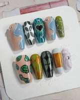 Mindbend extra short almond nails with chaotic abstract patterns and sculpted chrome shine